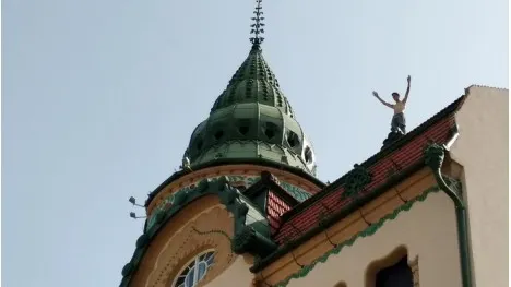VIDEO. Un tânăr dezbrăcat a ameninţat că se aruncă în gol de pe Palatul Vulturul Negru