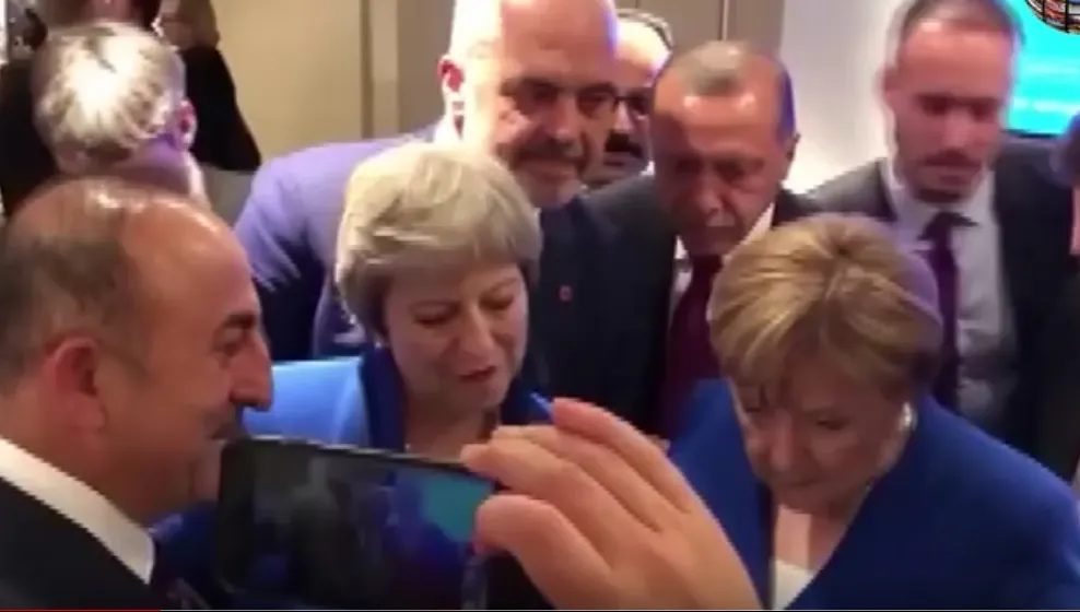 Imagini virale: Merkel, Erdogan și Theresa May se uită la meciul Croația-Anglia pe un telefon