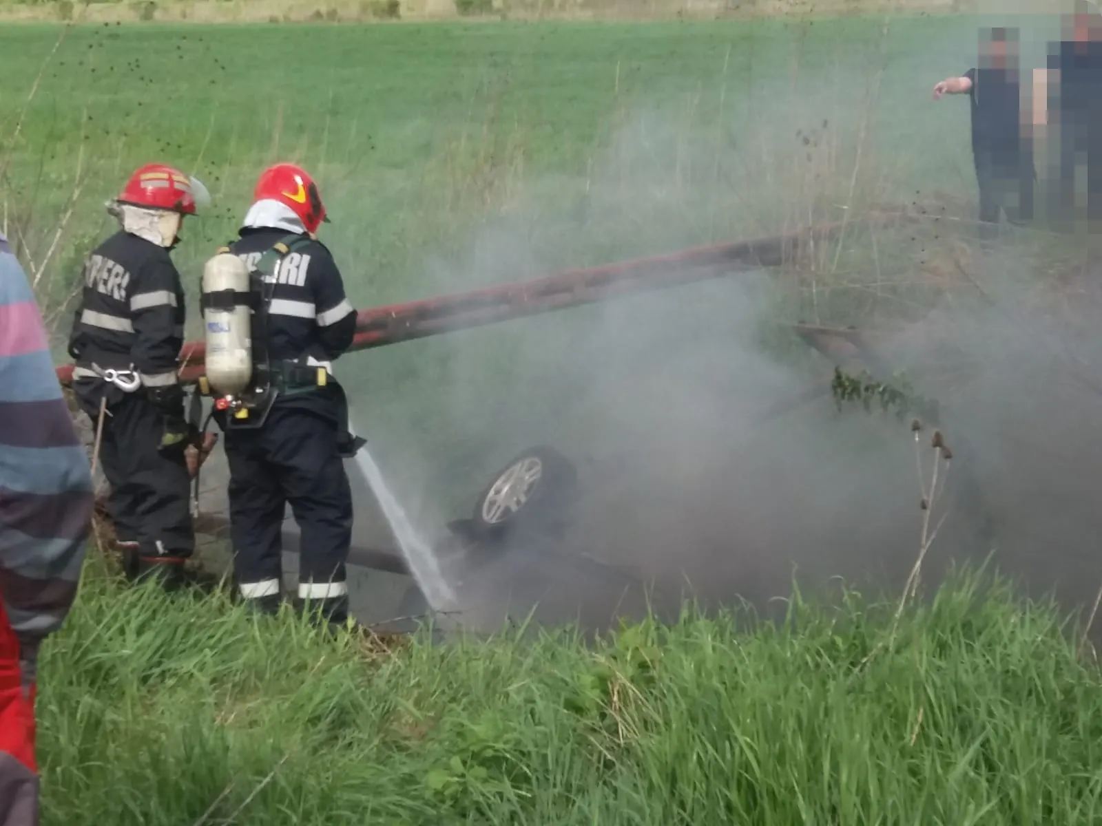 Imagini cumplite: O mașină a luat foc după ce s-a răsturnat într-un șanț. 5 victime
