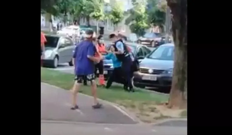 Femeie încătușată pentru a putea fi urcată în ambulanță