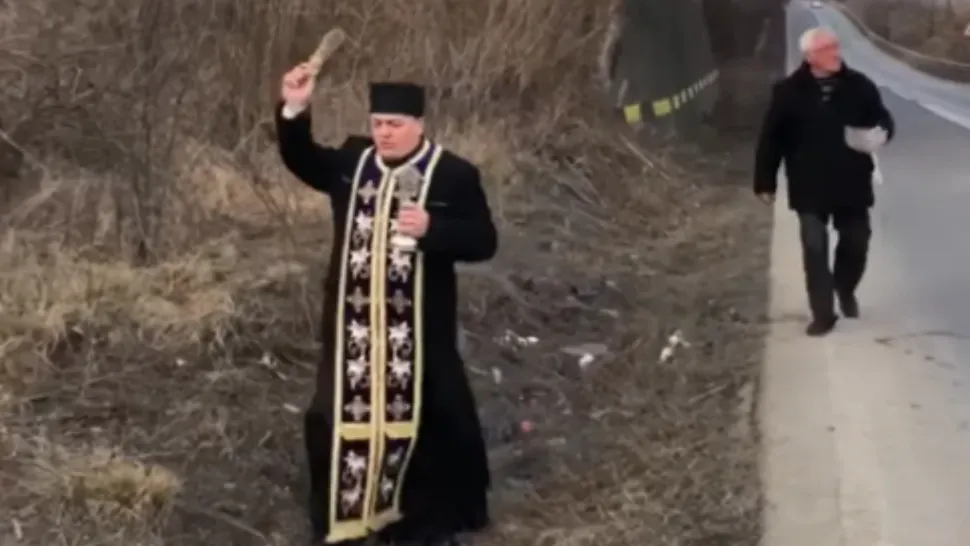 Preot care sfințește o curbă, în jud. Bacău / Captură foto Bacău.Net