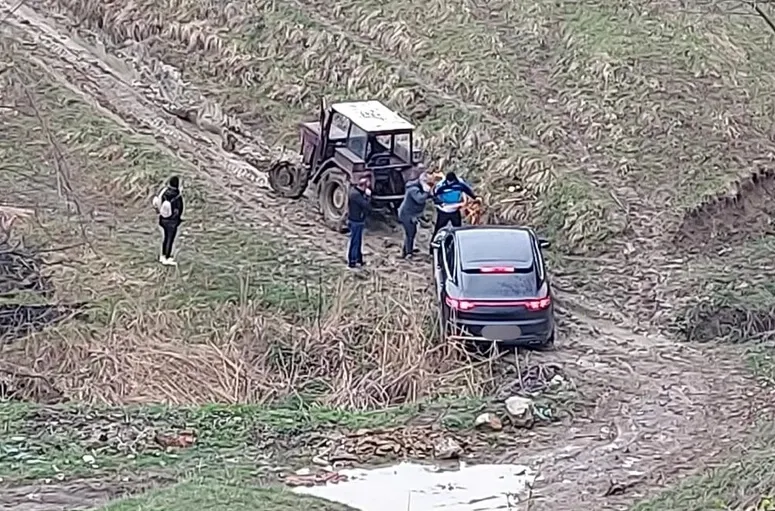 Porsche Cayenne, scos din noroi de un tractor vechi de peste 30 de ani. Operațiunea, asistată de jandarmi