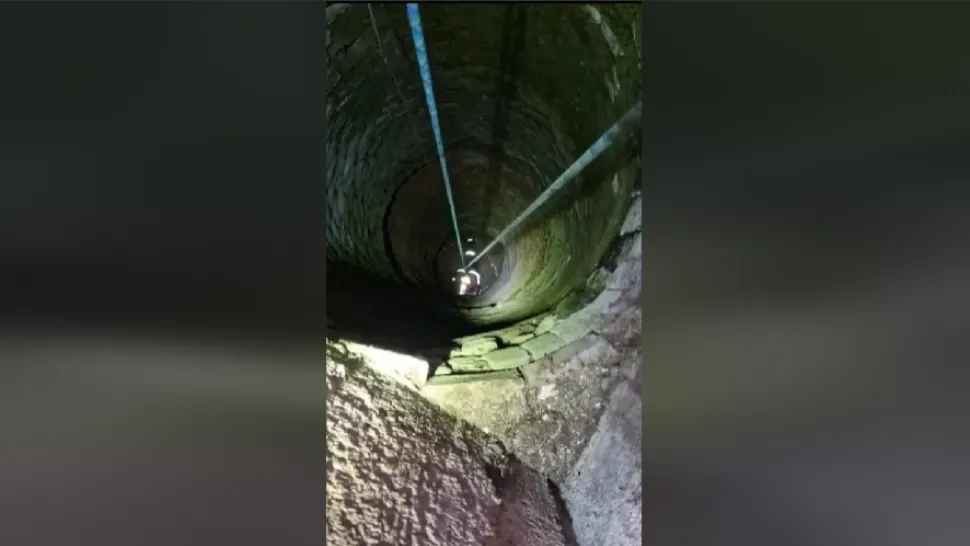 Momentul în care pompierii arădeni scot o pisica căzută într-o fântână. Foto: Facebook