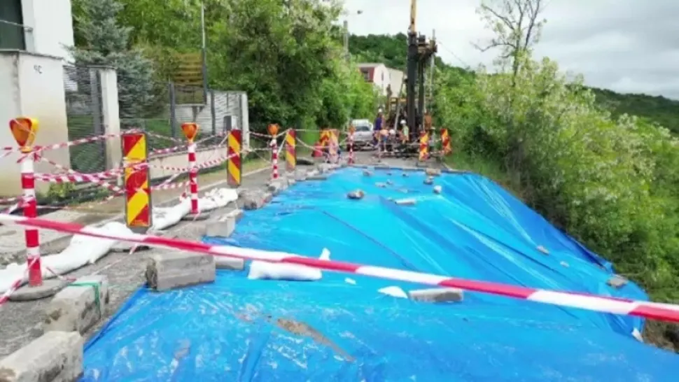 Stradă afectată de o alunecare de teren din Cluj-Napoca, acoperită temporar cu o prelată. Metoda „ingenioasă” folosită de autorități