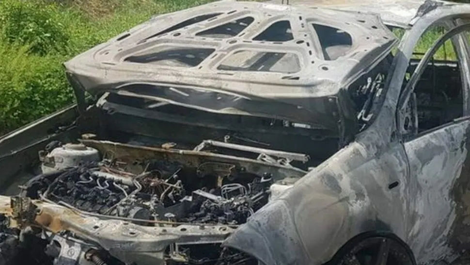 Caz terifiant: Cadavrul unui român a fost găsit legat cu lanțul de un stâlp și de o mașină în flăcări