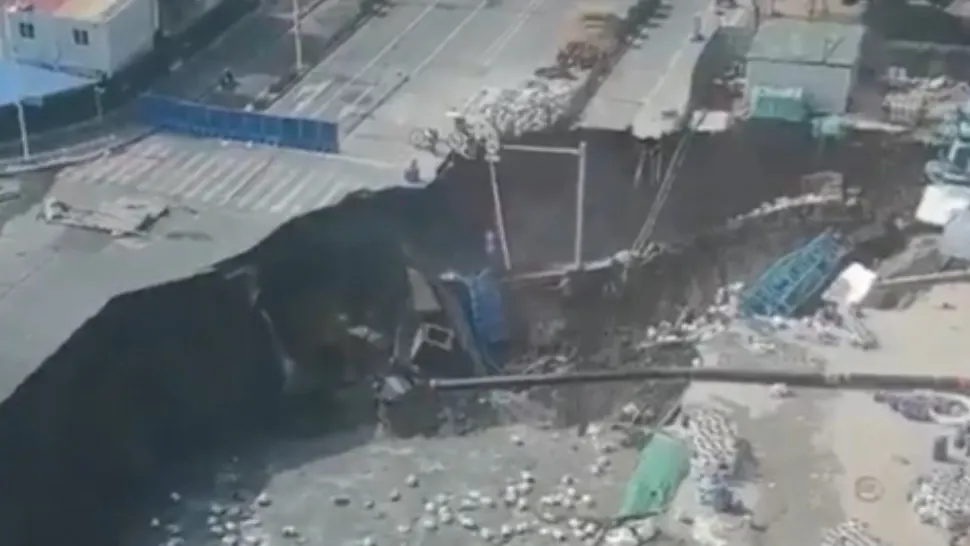 Momentul dramatic în care un crater uriaș înghite o șosea în China.
