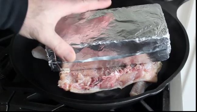 A învelit o cărămidă în folie de aluminiu și a pus-o peste puiul din tigaie. Motivul? E genial!