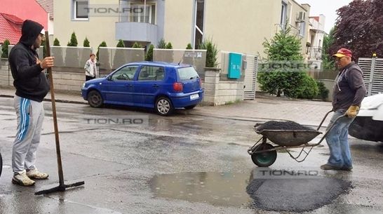 Gropi plombate pe ploaie. Explicația firmei: "În Germania se toarnă asfalt și când ninge"