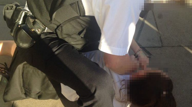 Imagini şocante! O adolescentă este târâtă pe asfalt de un poliţist în timp ce o arestează 