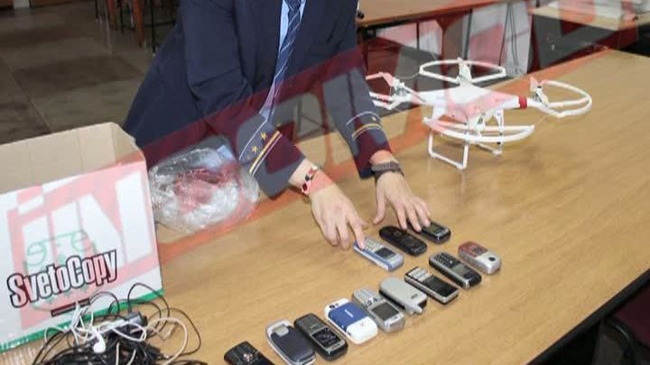 Telefon transportat cu drona după gratii 