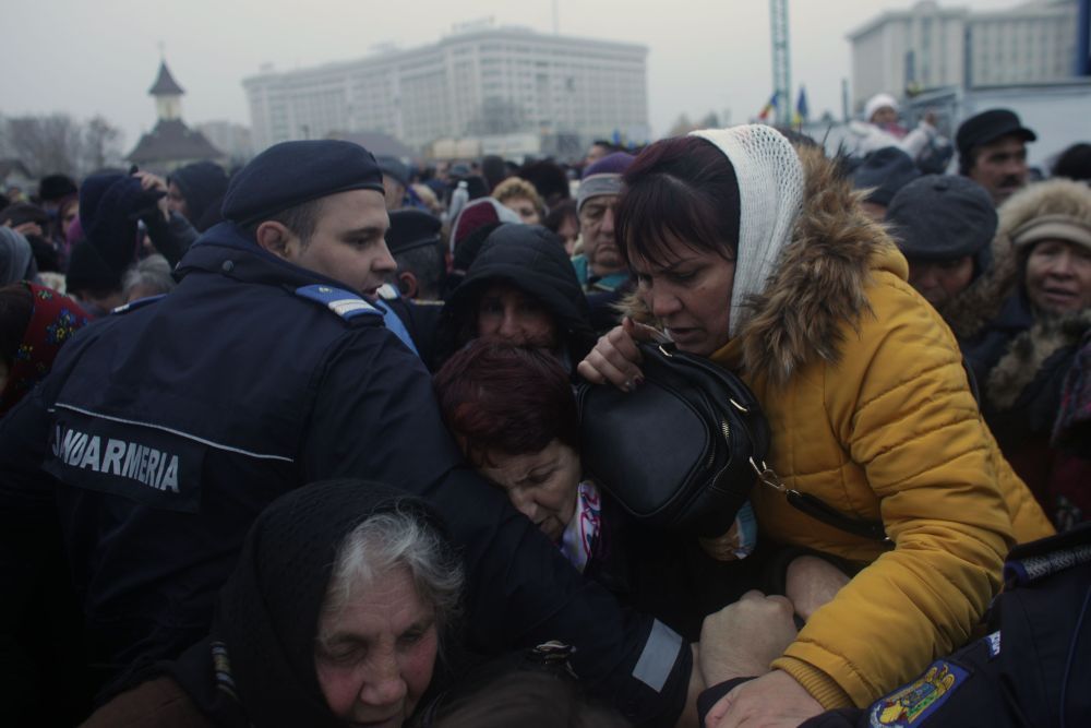 Pozele tulburătoare ale zilei la Catedrală. Oamenii care se îmbulzesc în frig, preoții și Mercedesul