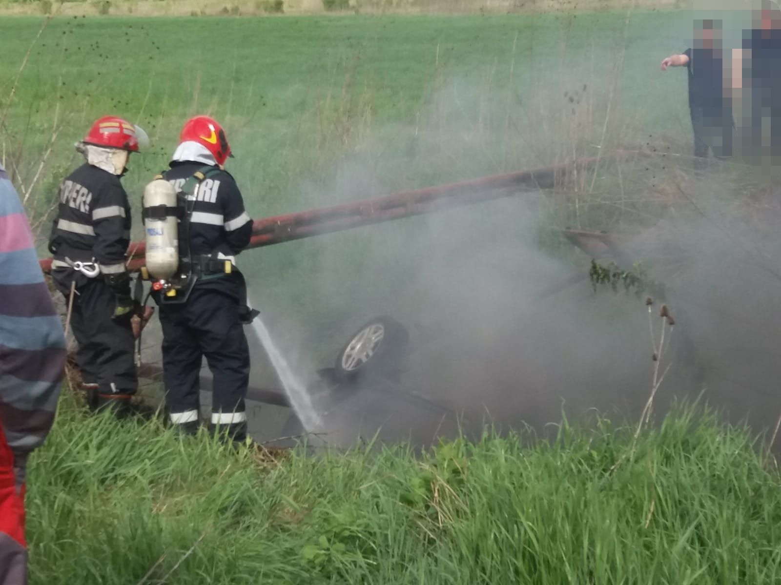 Imagini cumplite: O mașină a luat foc după ce s-a răsturnat într-un șanț. 5 victime