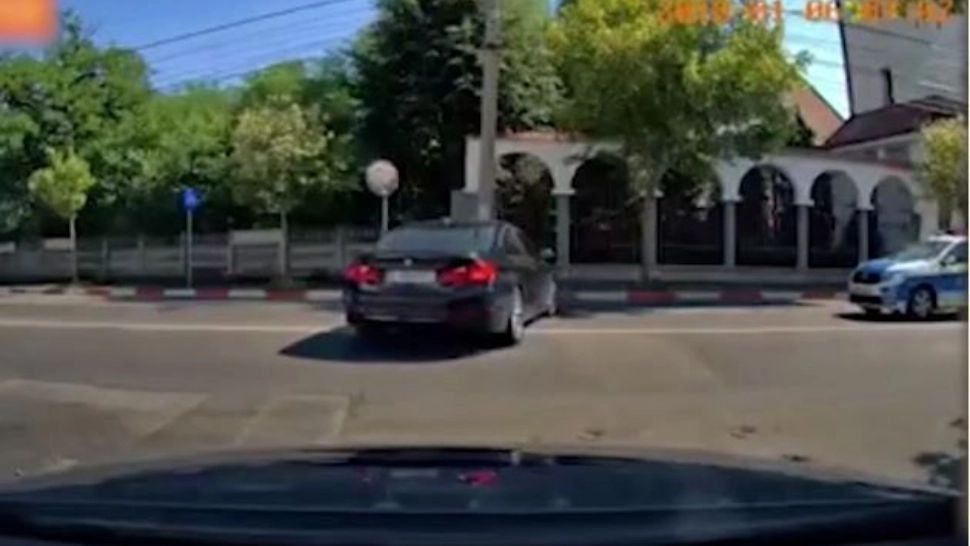 Momentul în care un conducător auto se asigură și intră în intersecți, dar mai avea puțin și lovea mașina poliției