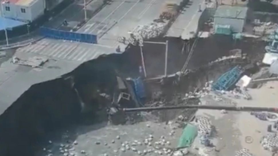 Momentul dramatic în care un crater uriaș înghite o șosea în China.