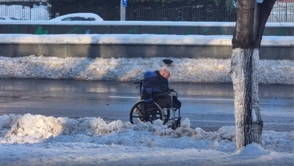 Om în scaun cu rotile, în zăpada din București. Imagini de pe cel mai circulat bulevard | VIDEO
