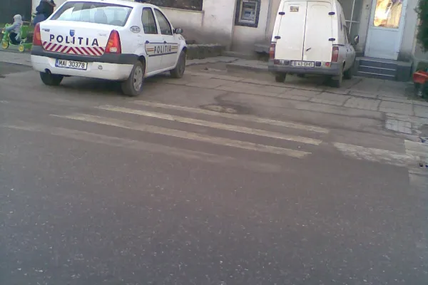 O maşină a poliţiei a fost parcată pe trotuar, exact lângă trecerea de pietoni