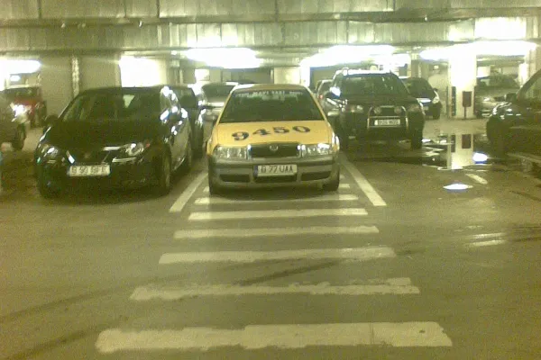 Taxi parcat pe trecerea de pietoni, în parcarea unui supermarket
