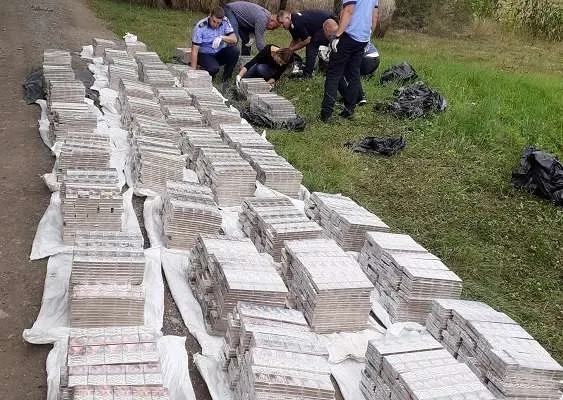 FOTO | Captură impresionantă a polițiștilor din Arad. Peste 20.000 de pachete de ţigări de contrabandă, descoperite lângă o lizieră