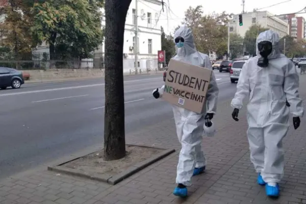 Imaginea MOMENTULUI! Doi studenţi din Iași protestează împotriva vaccinării anti-Covid-19 îmbrăcați în combinezoane