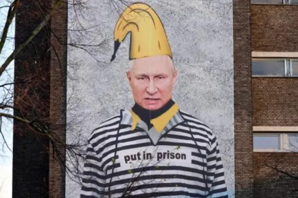 PUTIN, pe zidul unei clădiri dintr-un mare oraș, în haine de deținut și cu o banană în cap - Cine e autorul protestului