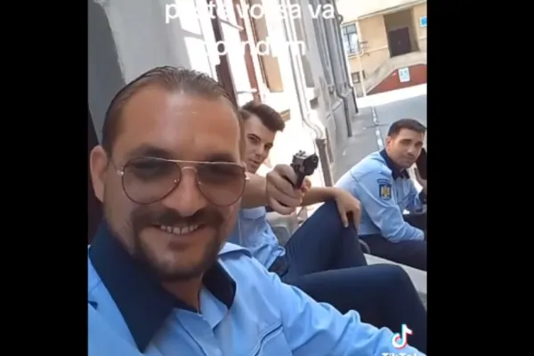 Polițiști falși, filmați în timp de flutură un pistol. „Venim peste voi să vă colindăm”