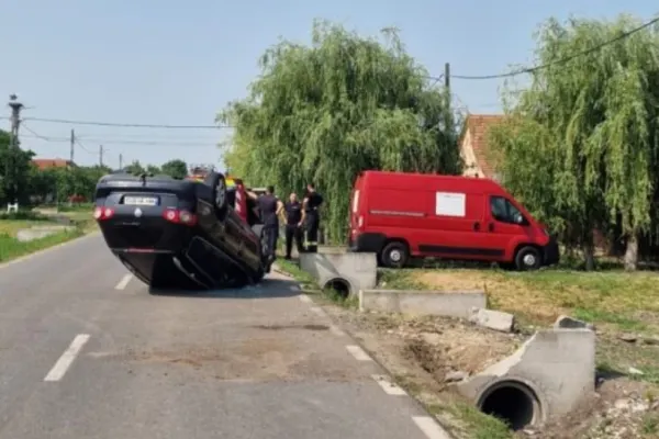 Accident demn de cascadorii râsului în județul Timiș. O mașină s-a răsturnat în mijlocul șoselei, după ce a lovit un cap de pod