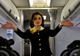 De ce ţin stewardesele mâinile la spate atunci când pasagerii urcă în avion
