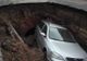 Maşină înghiţită de un crater uriaş surpat în parcare. Ce ascundea groapa şi de ce NU va fi astupată
